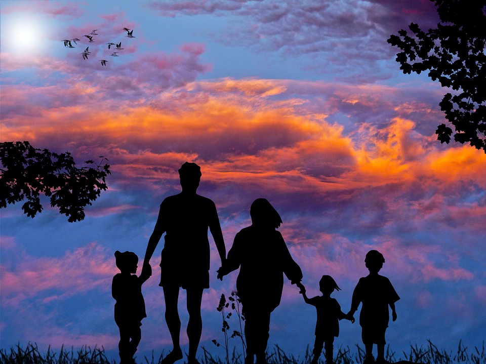 perhe kävelee auringonlaskuun